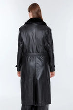 Back view of a long black distressed leather jacket with faux fur collar on a model