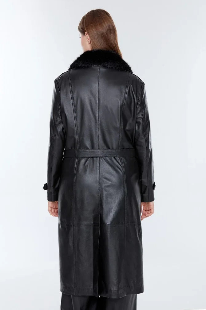 Back view of a long black distressed leather jacket with faux fur collar on a model